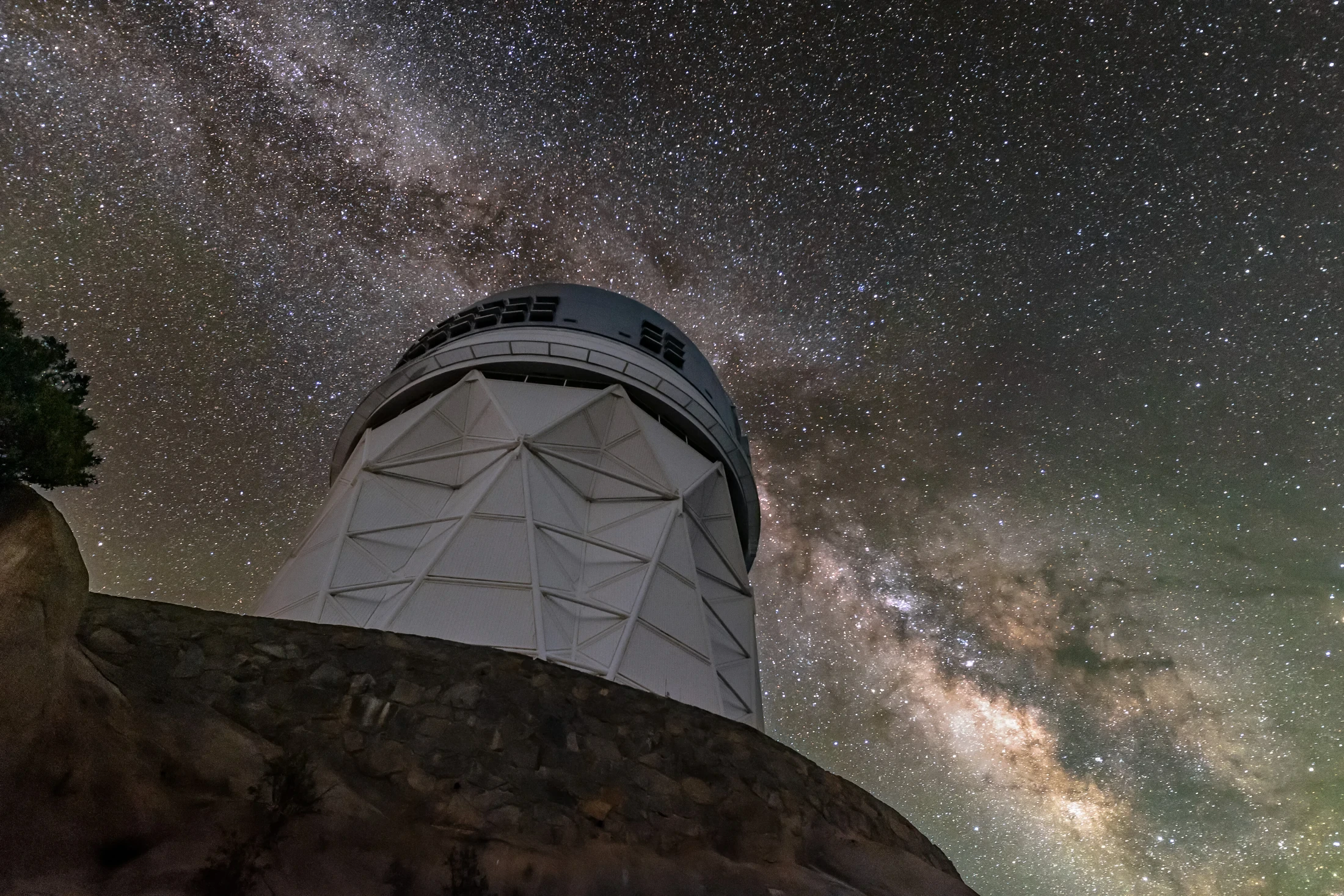 The Mayall telescope dome at Kitt Peak beneath the dense star field and bright band of the Milky Way.