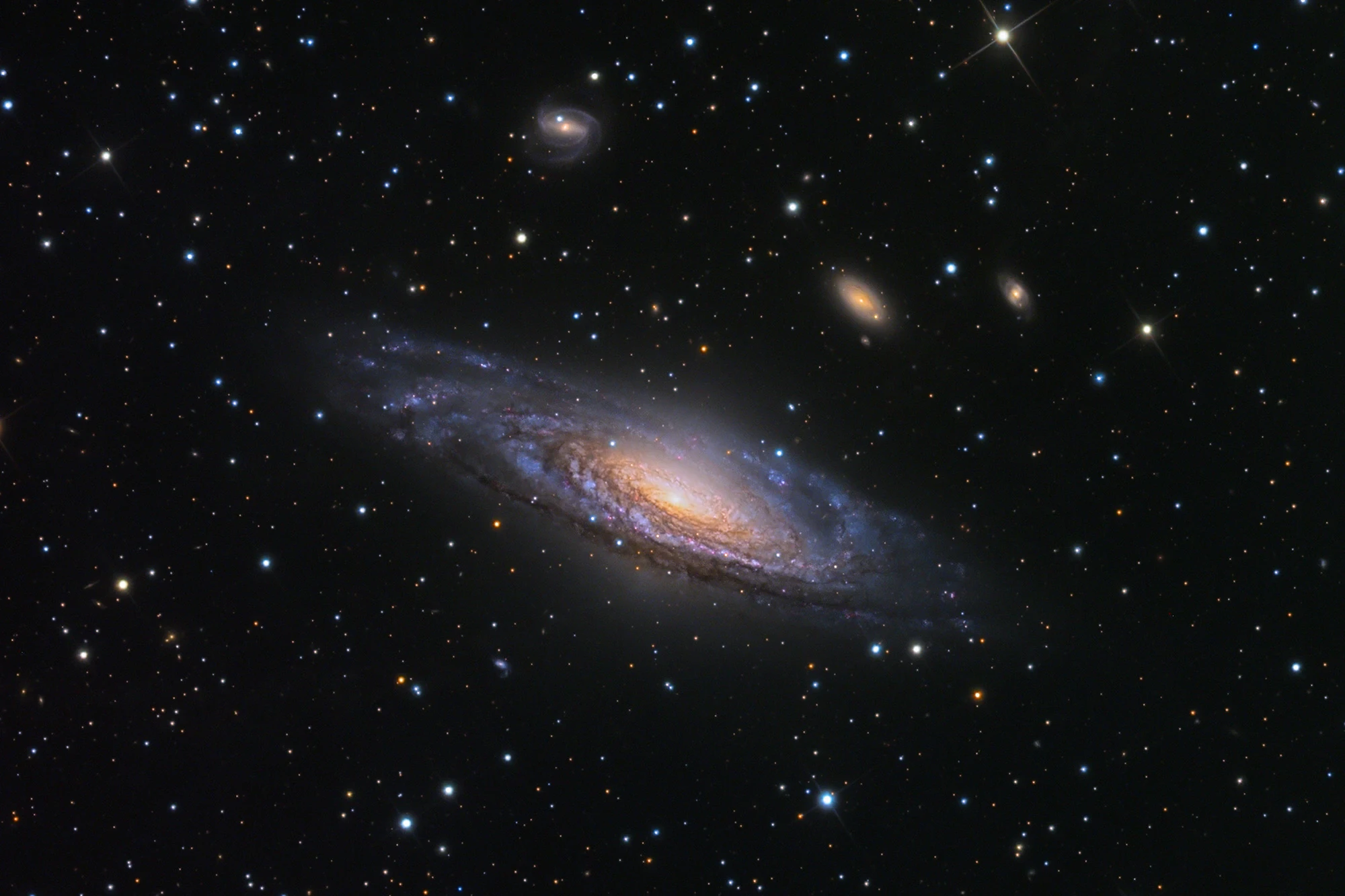 The tilted spiral galaxy NGC 7331 amid smaller galaxies and stars, photographed with the Schulman Telescope.
