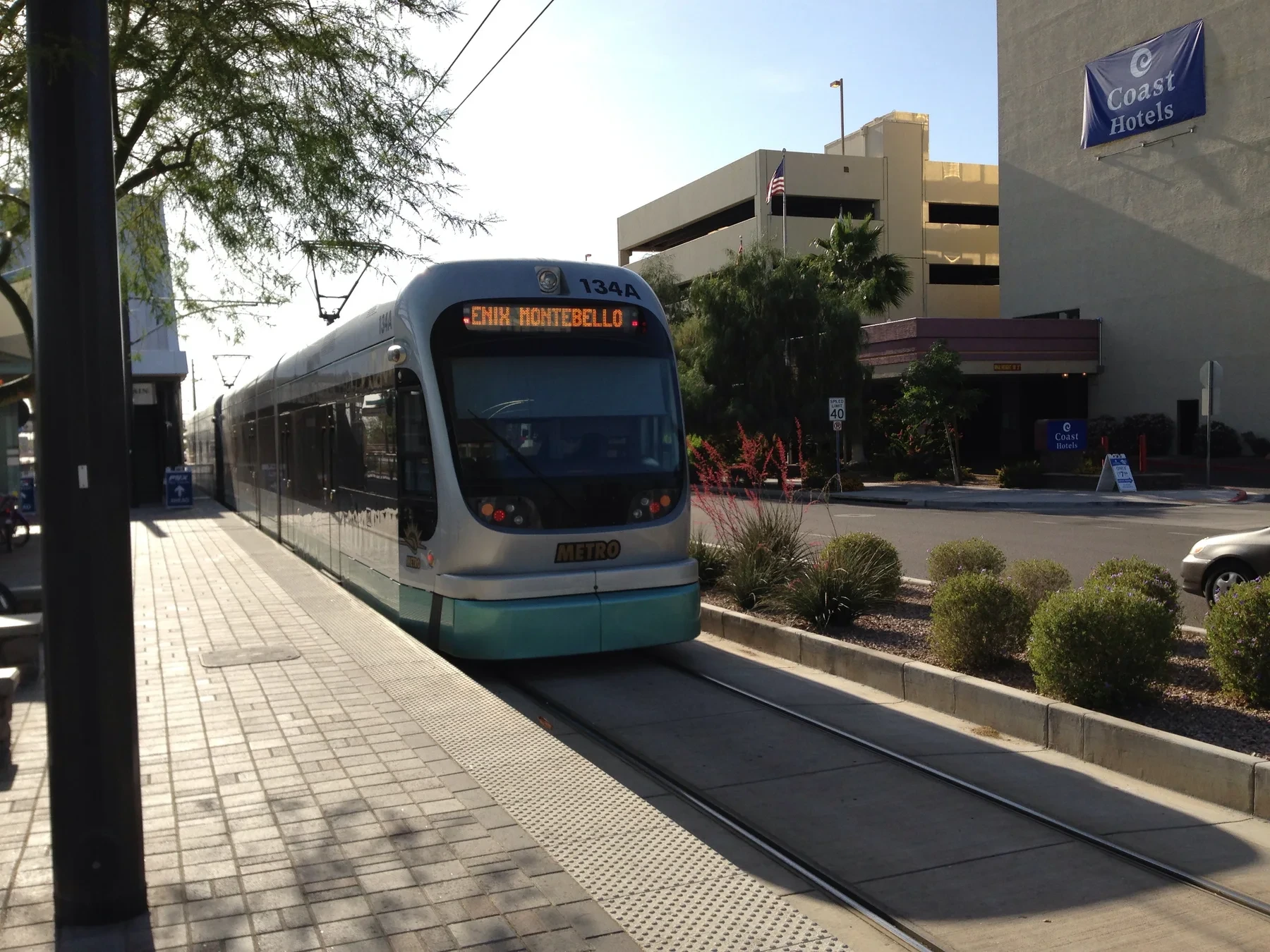 A silver and teal Phoenix light-rail train beside the platform at 44th Street and Washington.