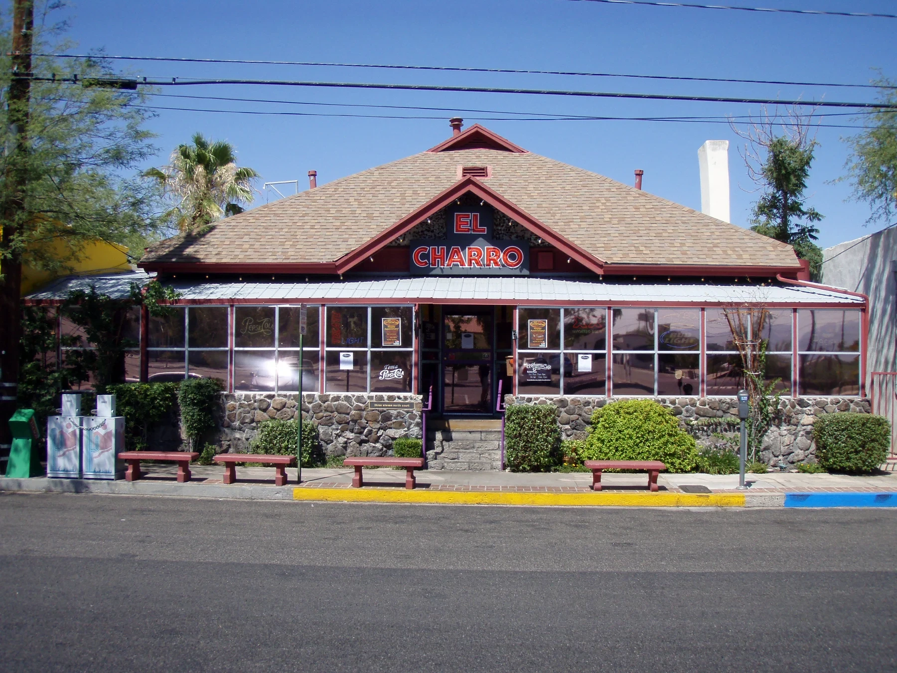 El Charro Café's downtown façade, with its red sign, porch windows and front steps.