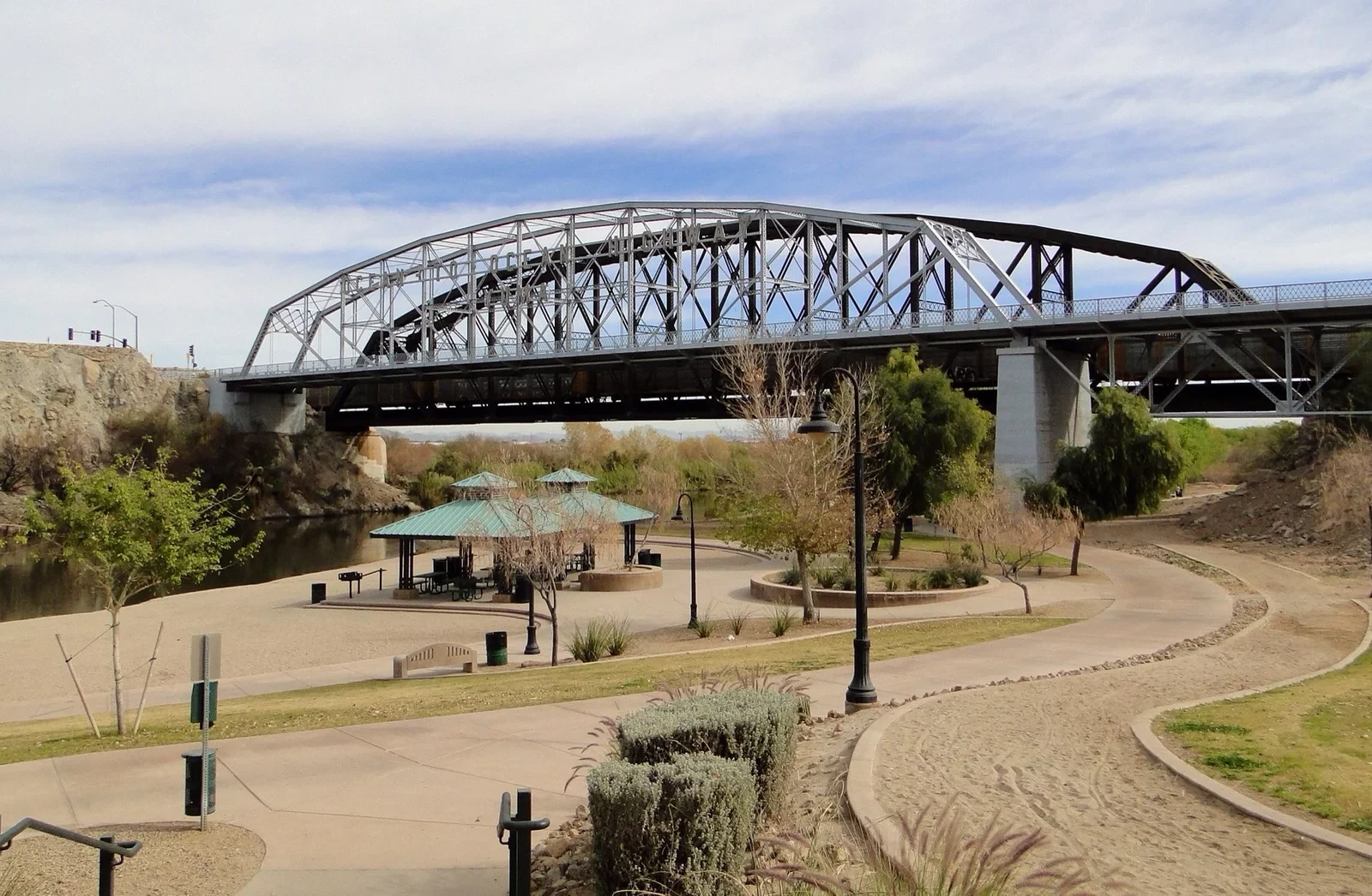 Ocean to Ocean Bridge above the Colorado River, with a pavilion and curving park paths below.