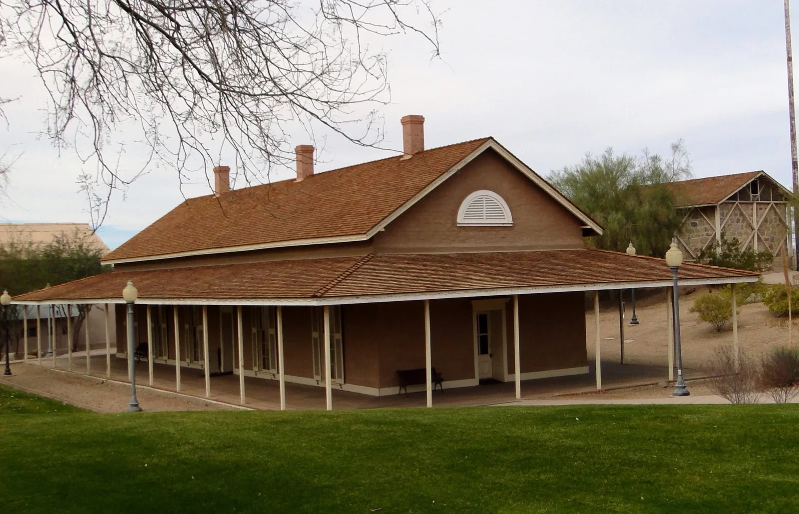 The former Army depot quartermaster office with its long shaded veranda and red shingle roof.