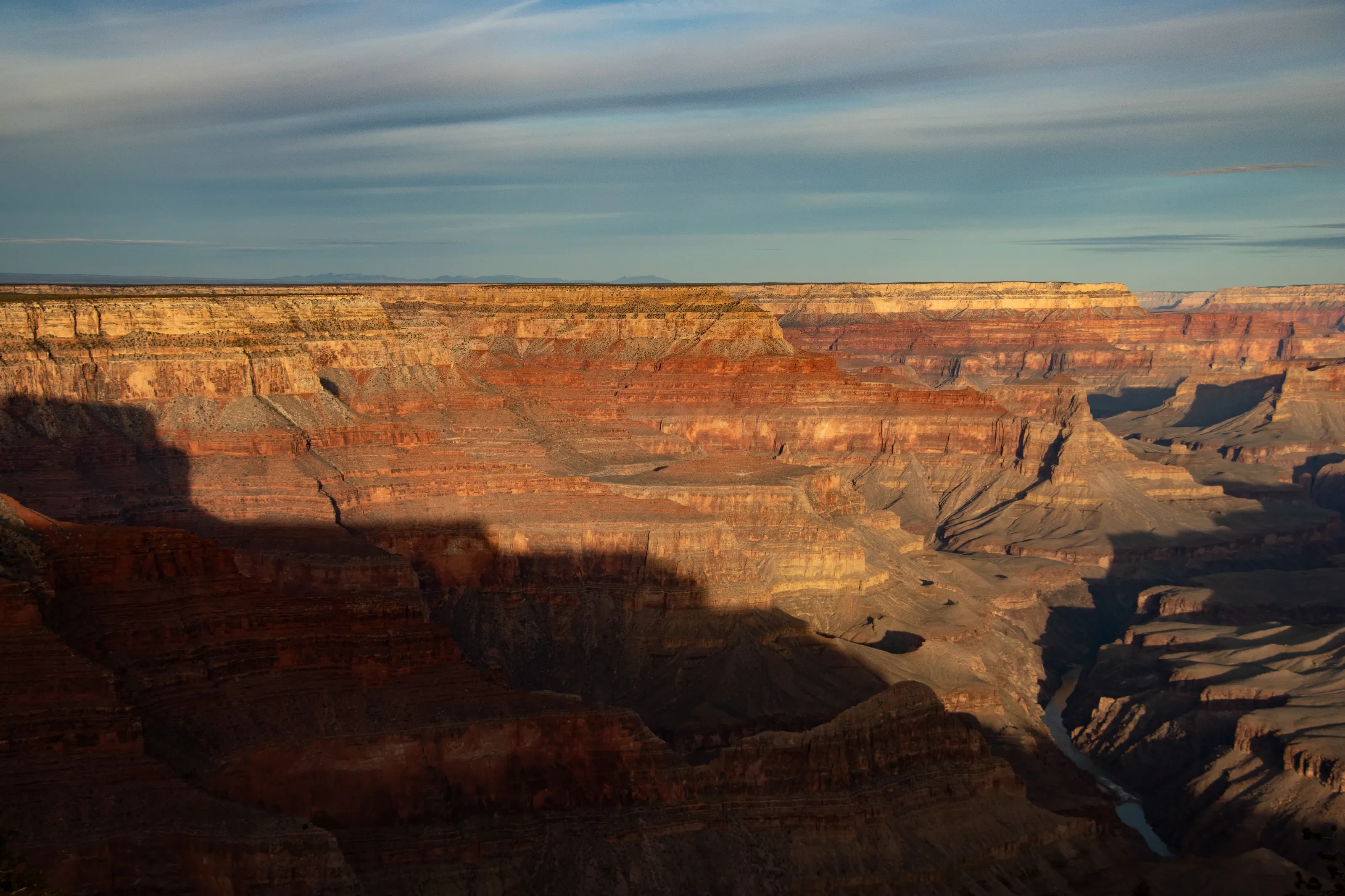 Sunlit orange rock layers and deep valleys at the Grand Canyon