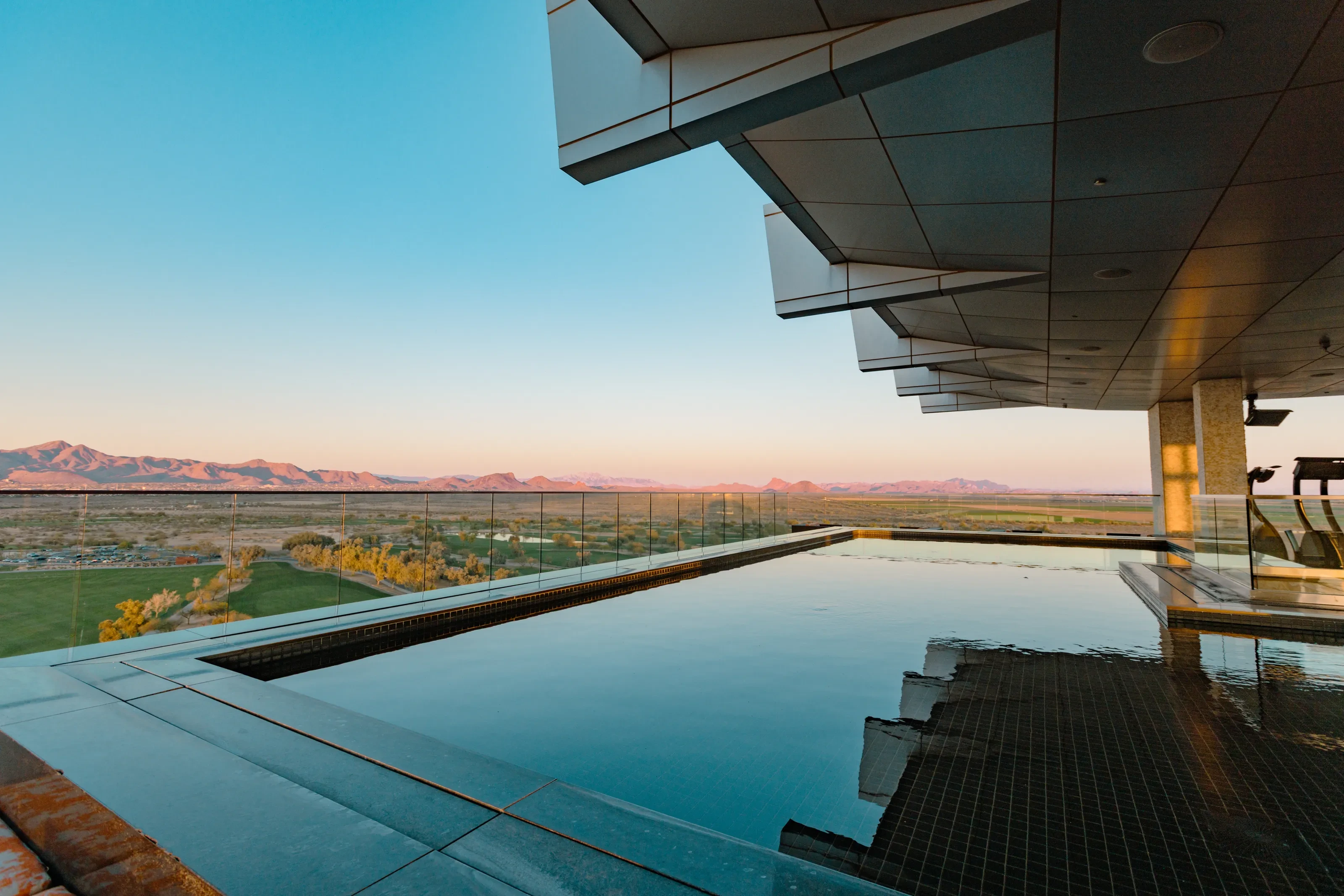 A reflective Scottsdale rooftop pool overlooking desert mountains in evening light